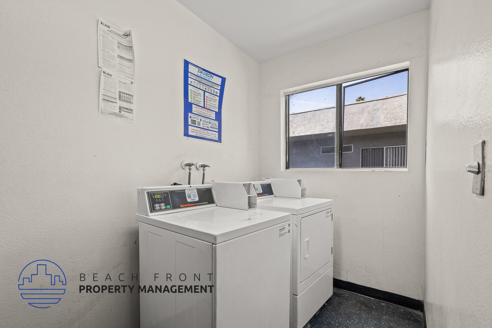 A clean, white-walled office space with a window, a desk, and a computer.